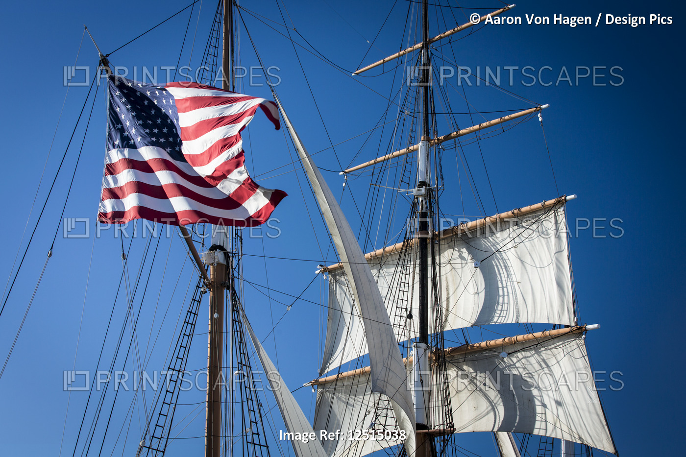 American flag hanging on a sailboat against a blue sky; San Diego, California, ...