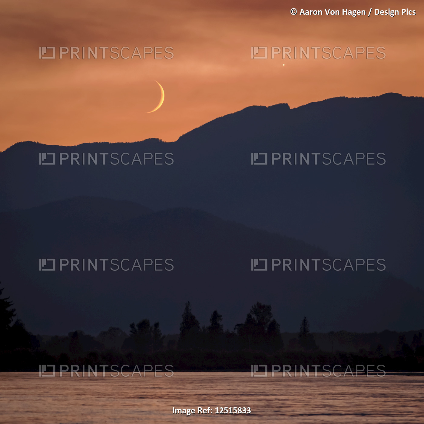The moon and Venus in an orange sky over the silhouetted mountains, Fraser ...