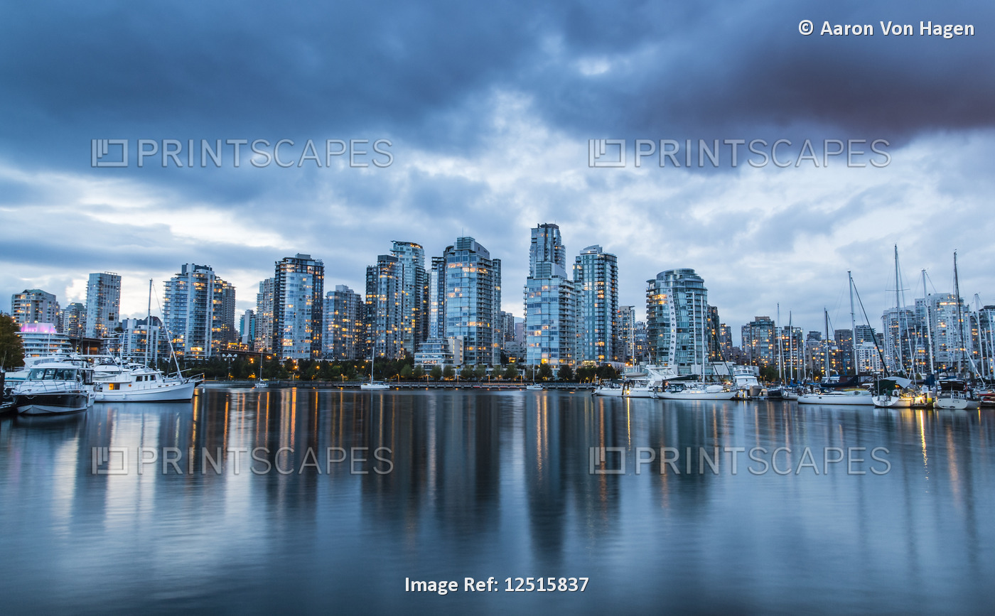 Skyline of residential buildings along the waterfront with boats in the harbour ...