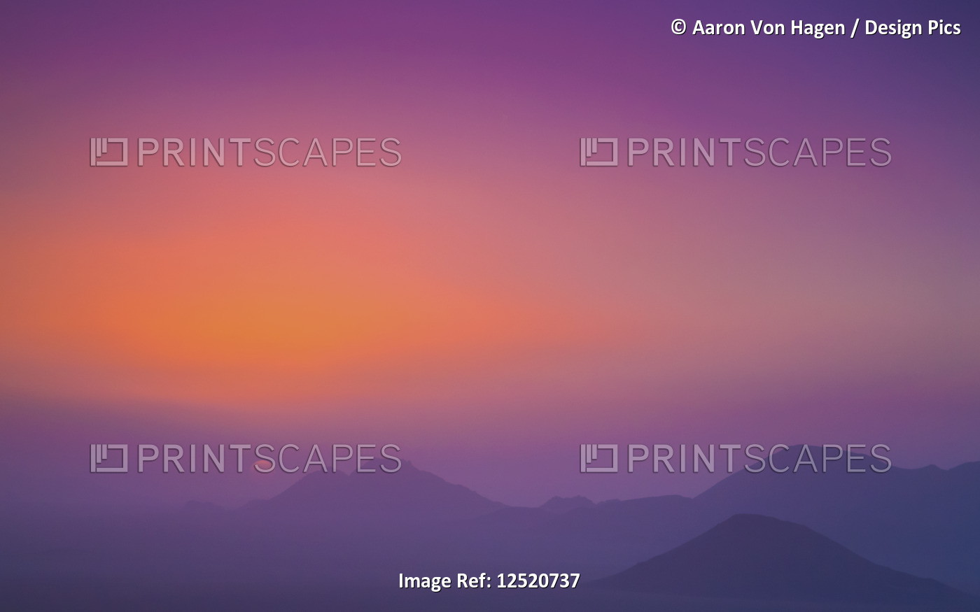 A pink and purple sky with silhouetted mountains; Namibia